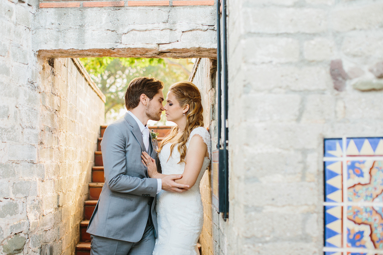 The couple leaning against a brick wall. 