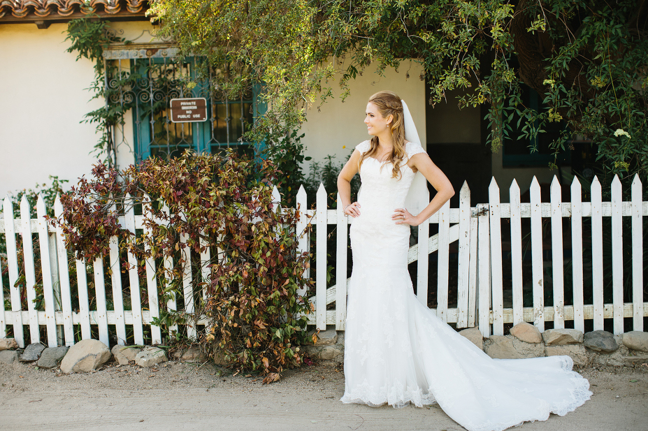 A portrait of the bride in front of a fence. 