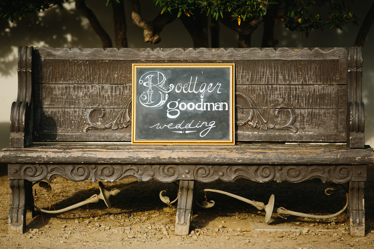 A wedding sign on a wood bench. 