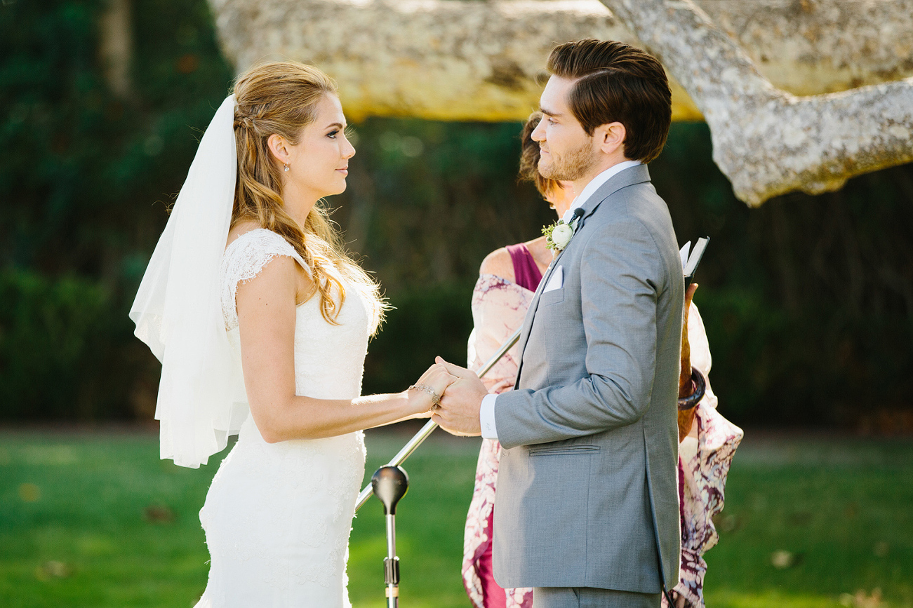 The bride and groom holding hands during the ceremony. 