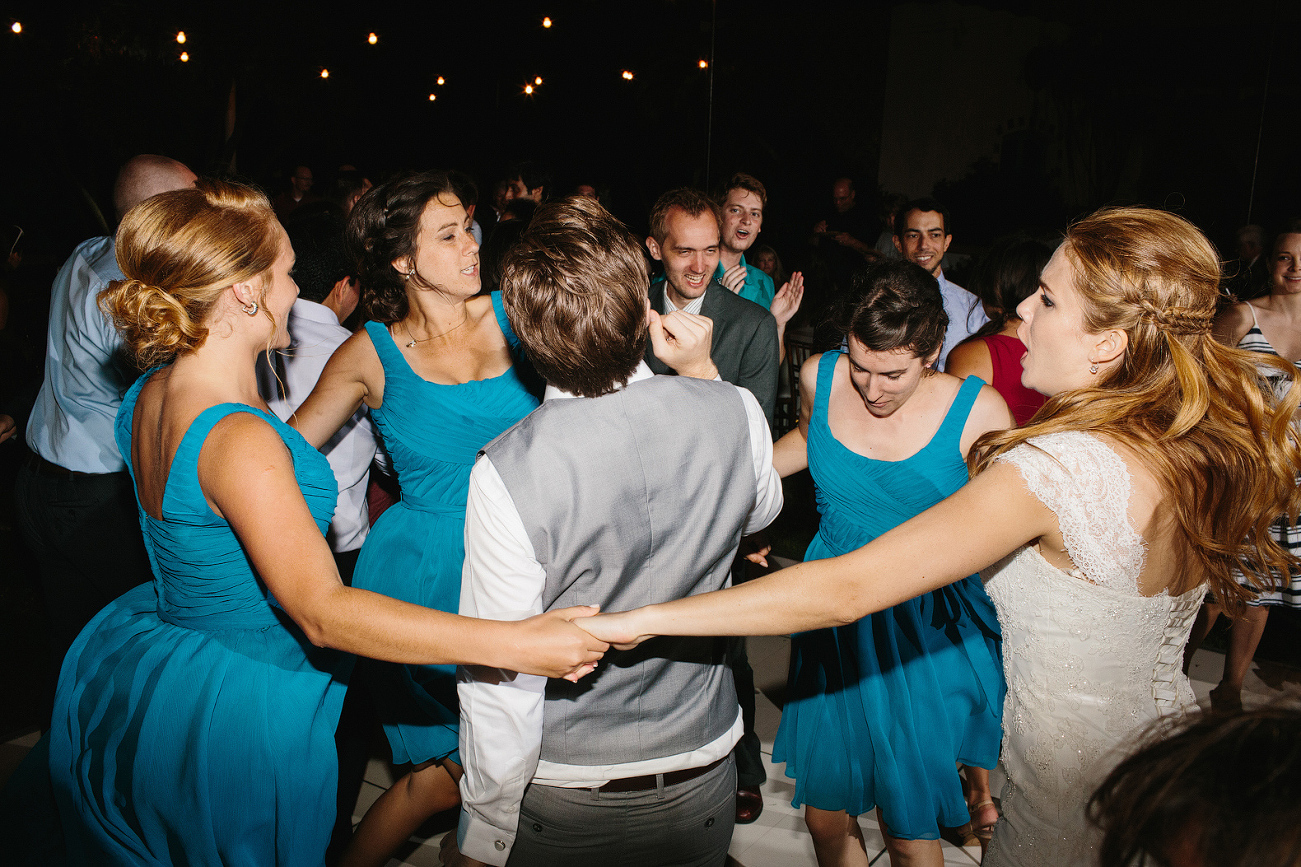 The bridesmaids and bride dancing around the groom. 