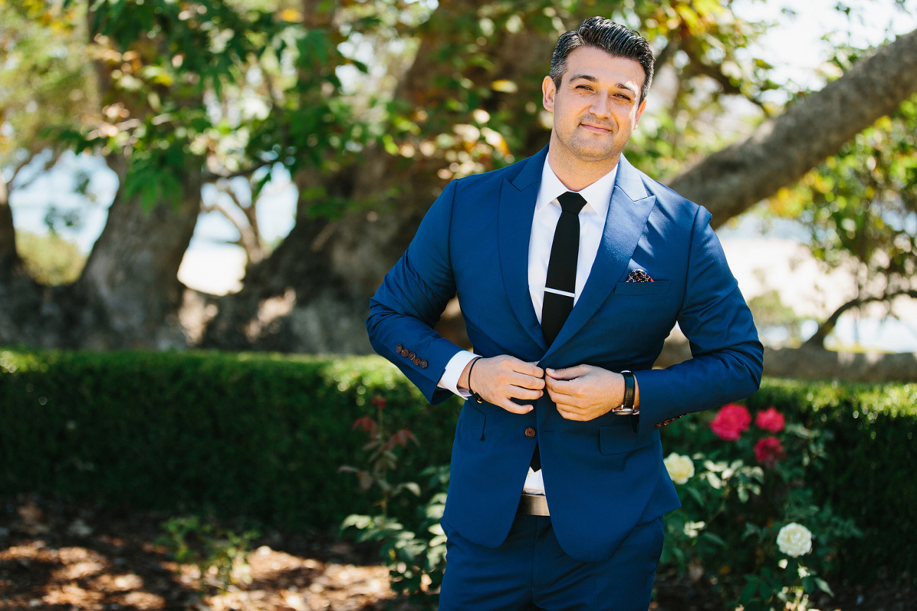 Hajime buttoning his navy blue suit. 