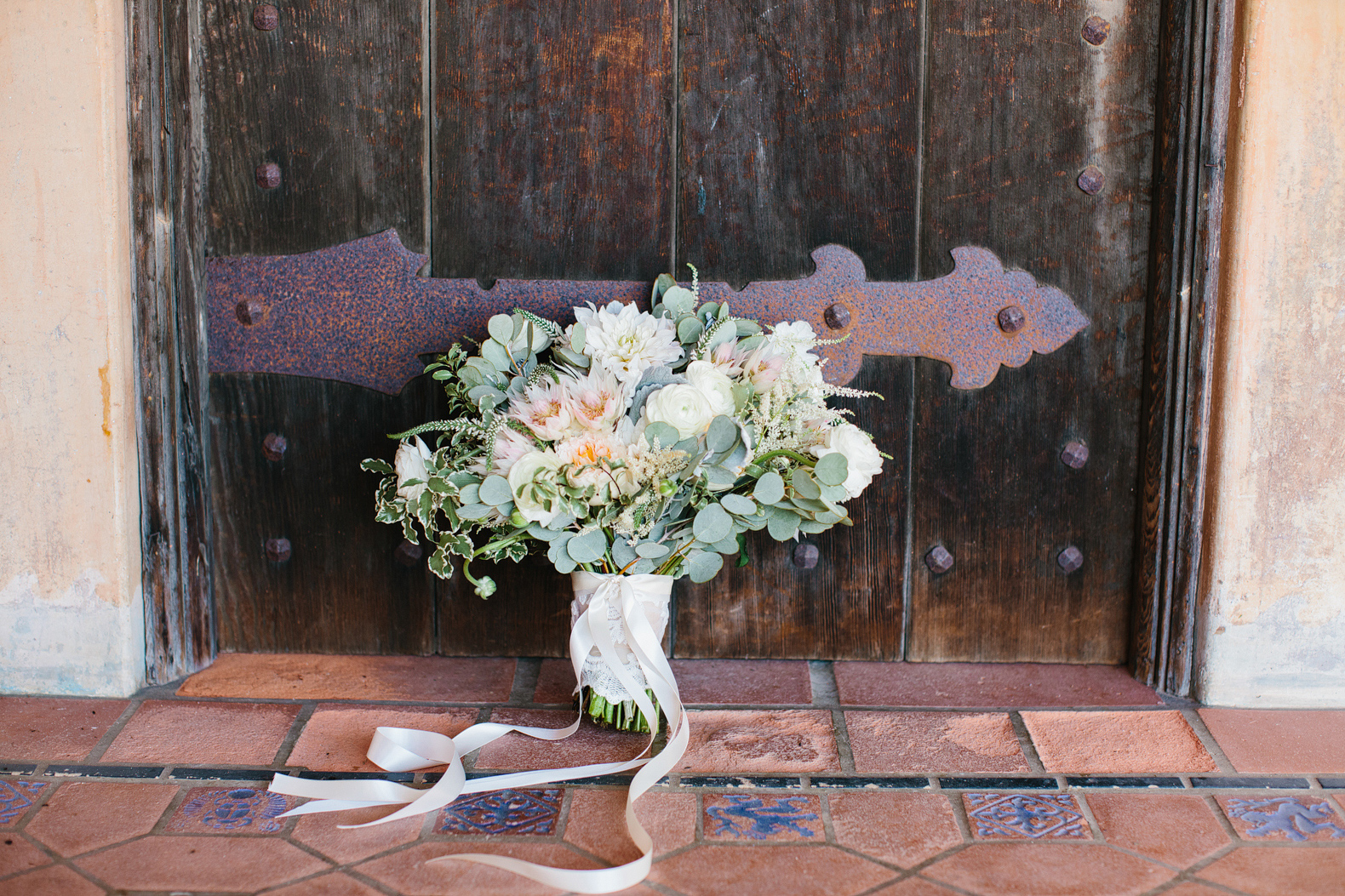 The bridal bouquet against a wood door. 