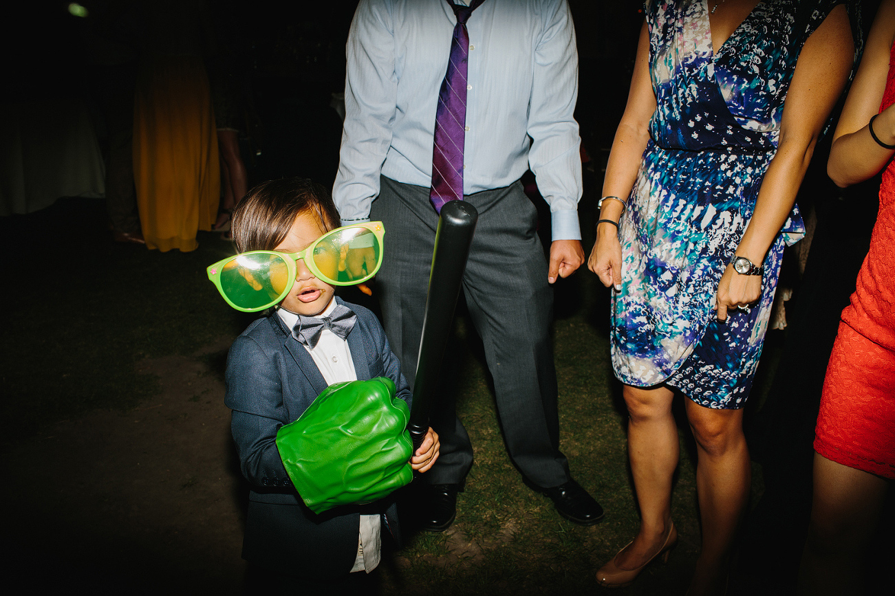 The ring bearer playing with photobooth props. 