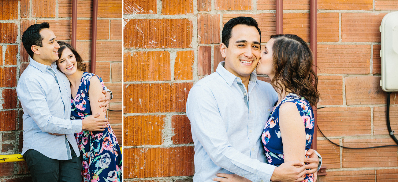 The couple near a brick building. 