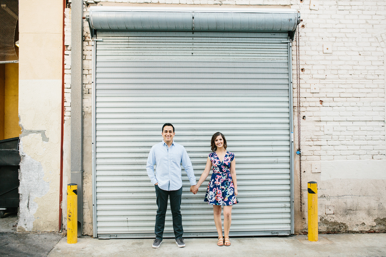 Alix and Anthony in front of a roll-up door. 