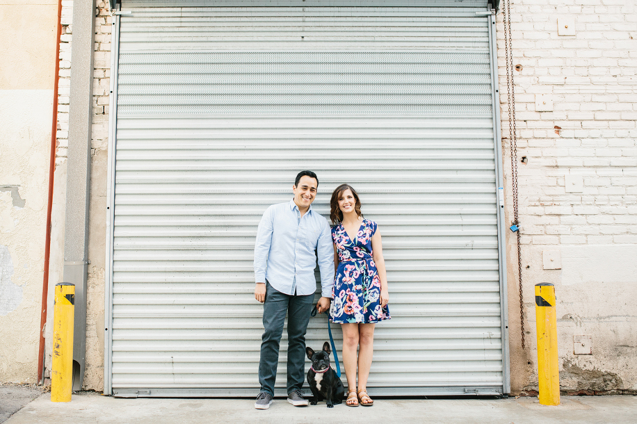 A portrait of the couple with their French bulldog. 