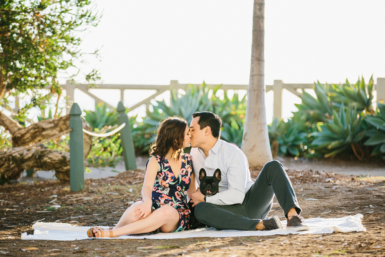 The couple sitting on a blanket. 