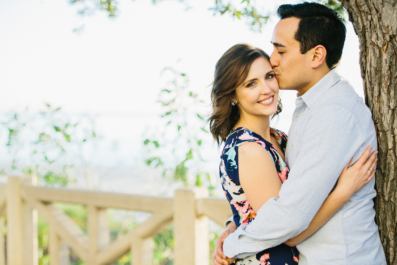 The couple leaning on a tree. 