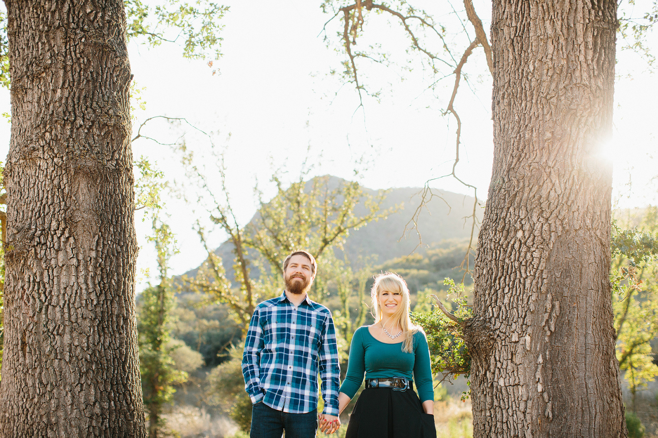 Lindsay and Josh standing between two trees. 