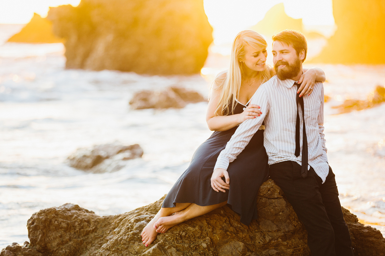 Lindsay and Josh sitting on a rock at sunset. 