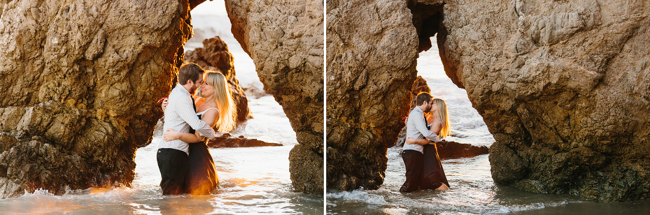 The couple stnading in water under a rock. 