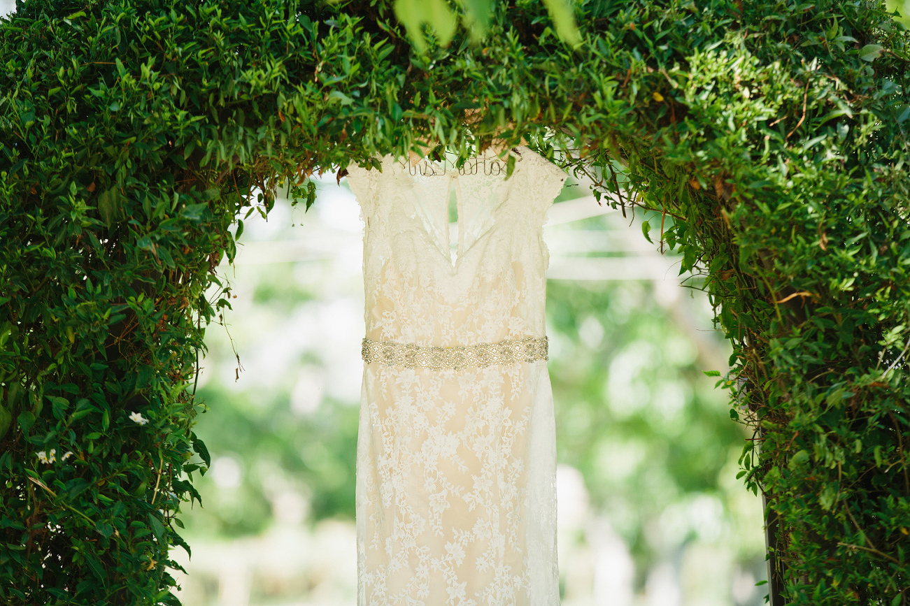 The wedding dress hanging in an arch. 