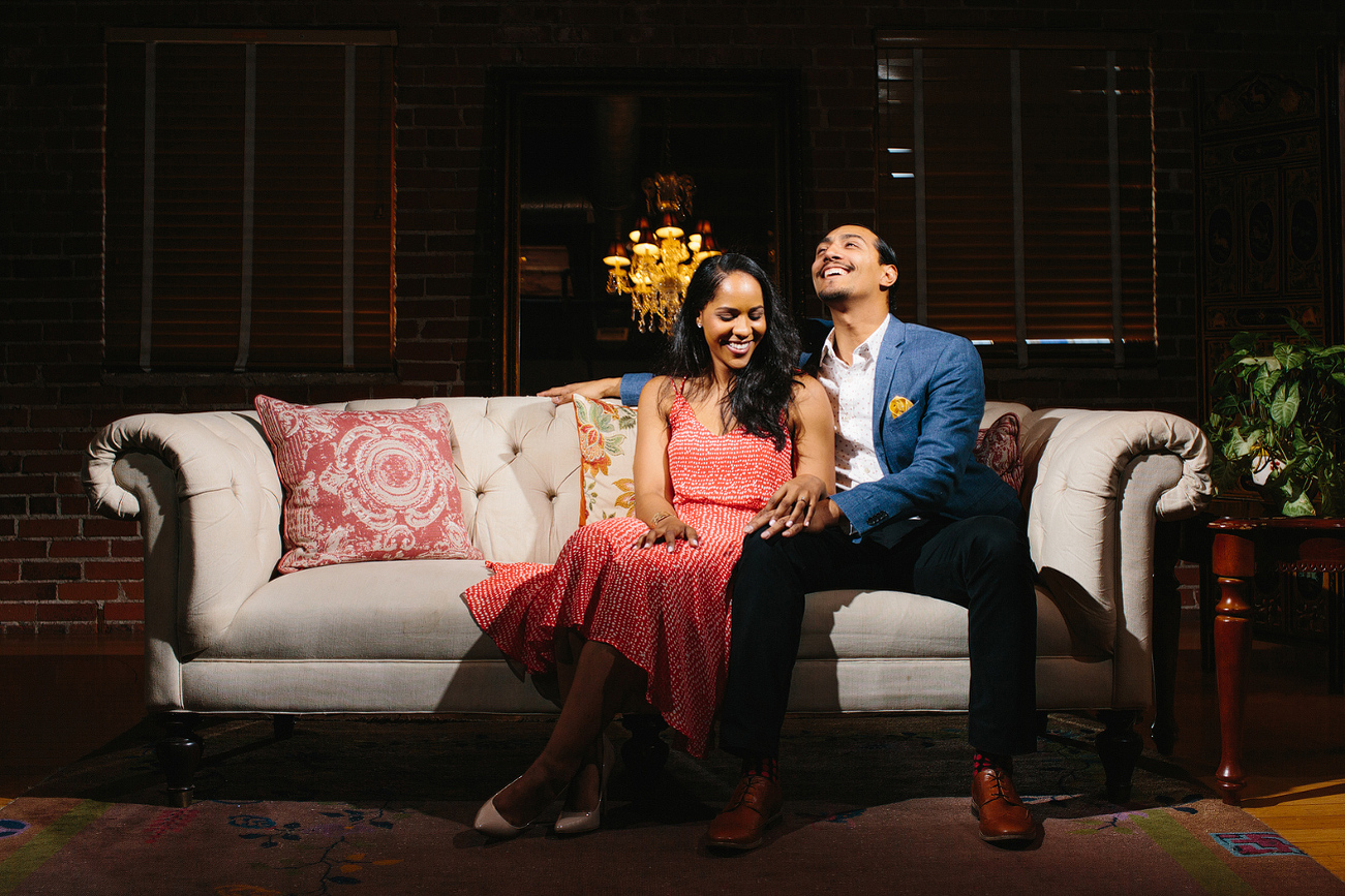 Alanna and David laughing on a couch. 