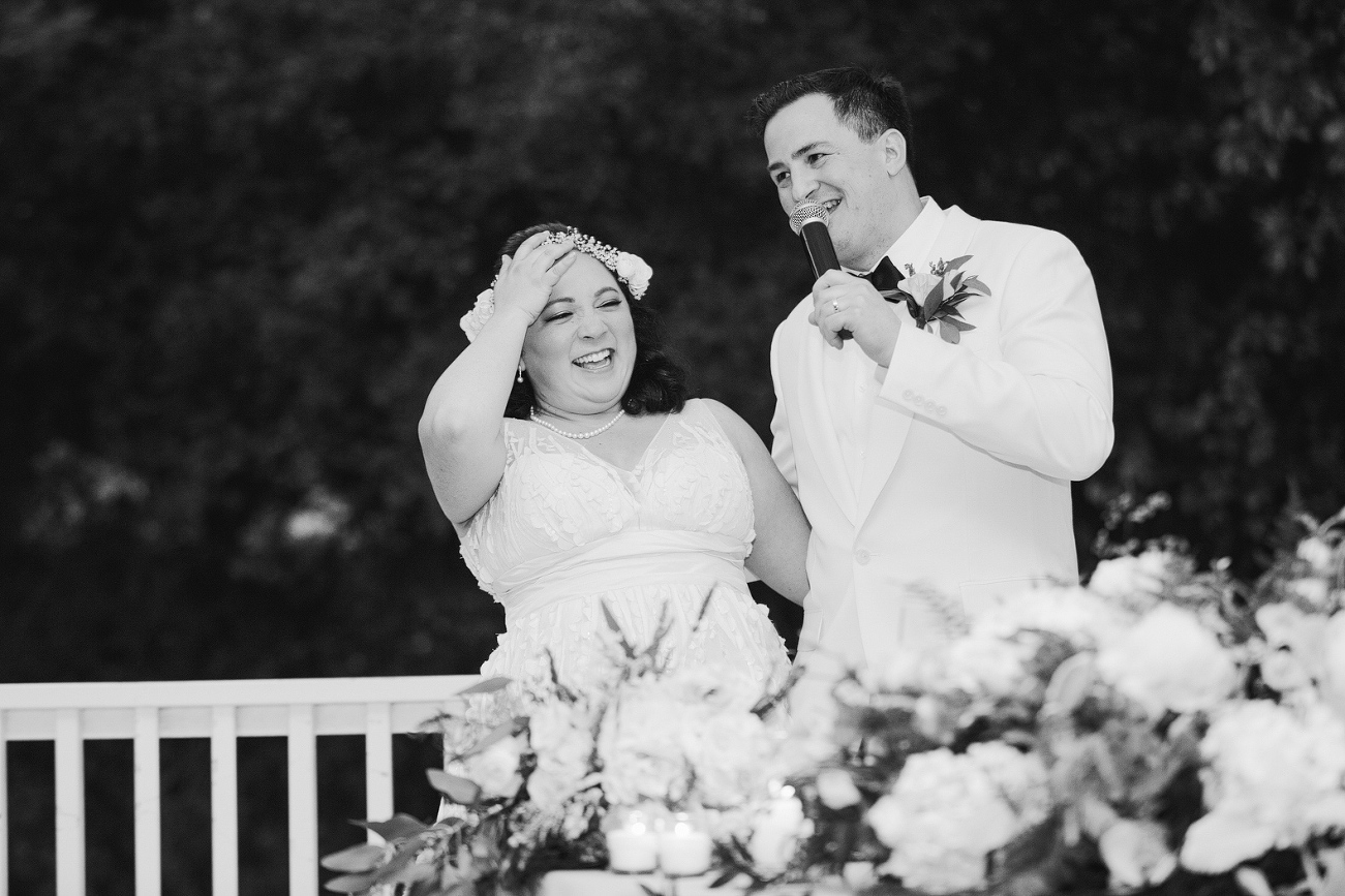 The bride and groom laughing during the toast. 