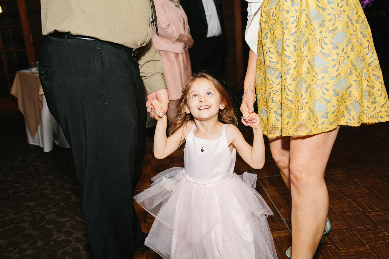 A little girl dancing with her parents. 