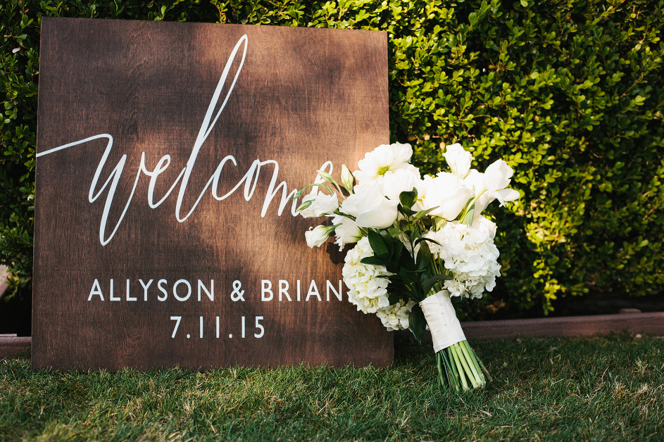 A welcome sign and bridal bouquet. 