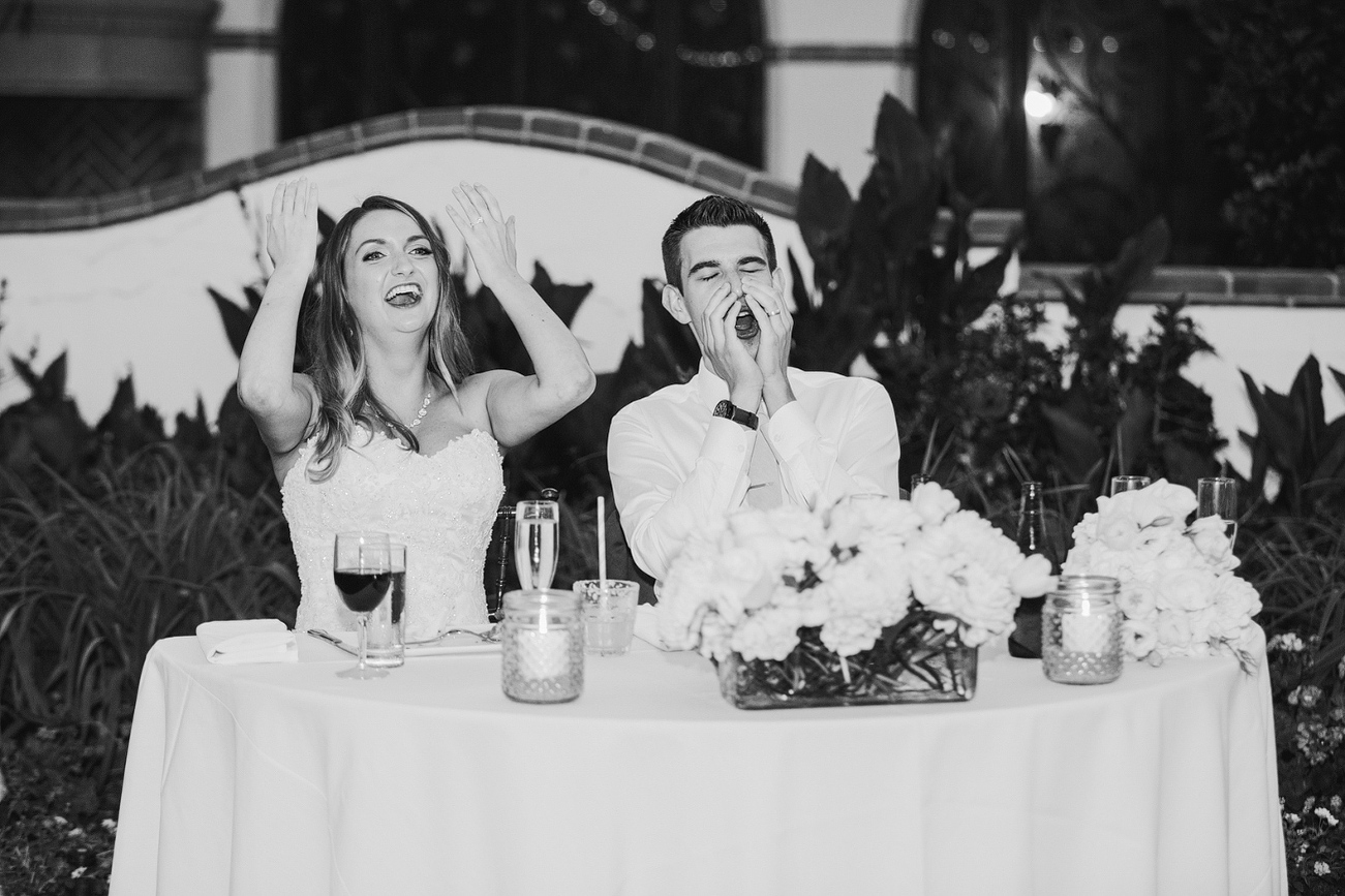 The couple laughing during the toast. 