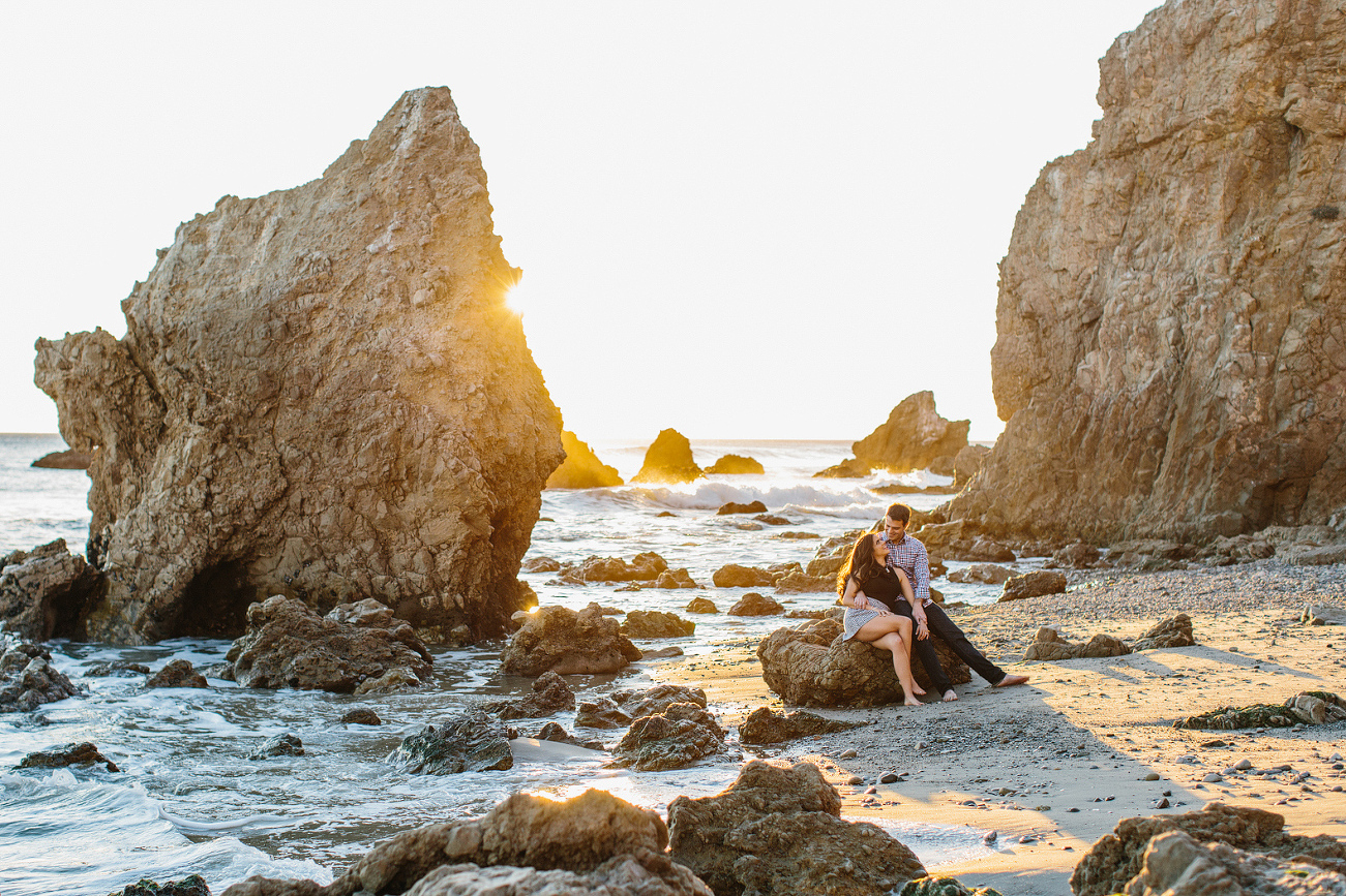 The couple sitting on a rock. 