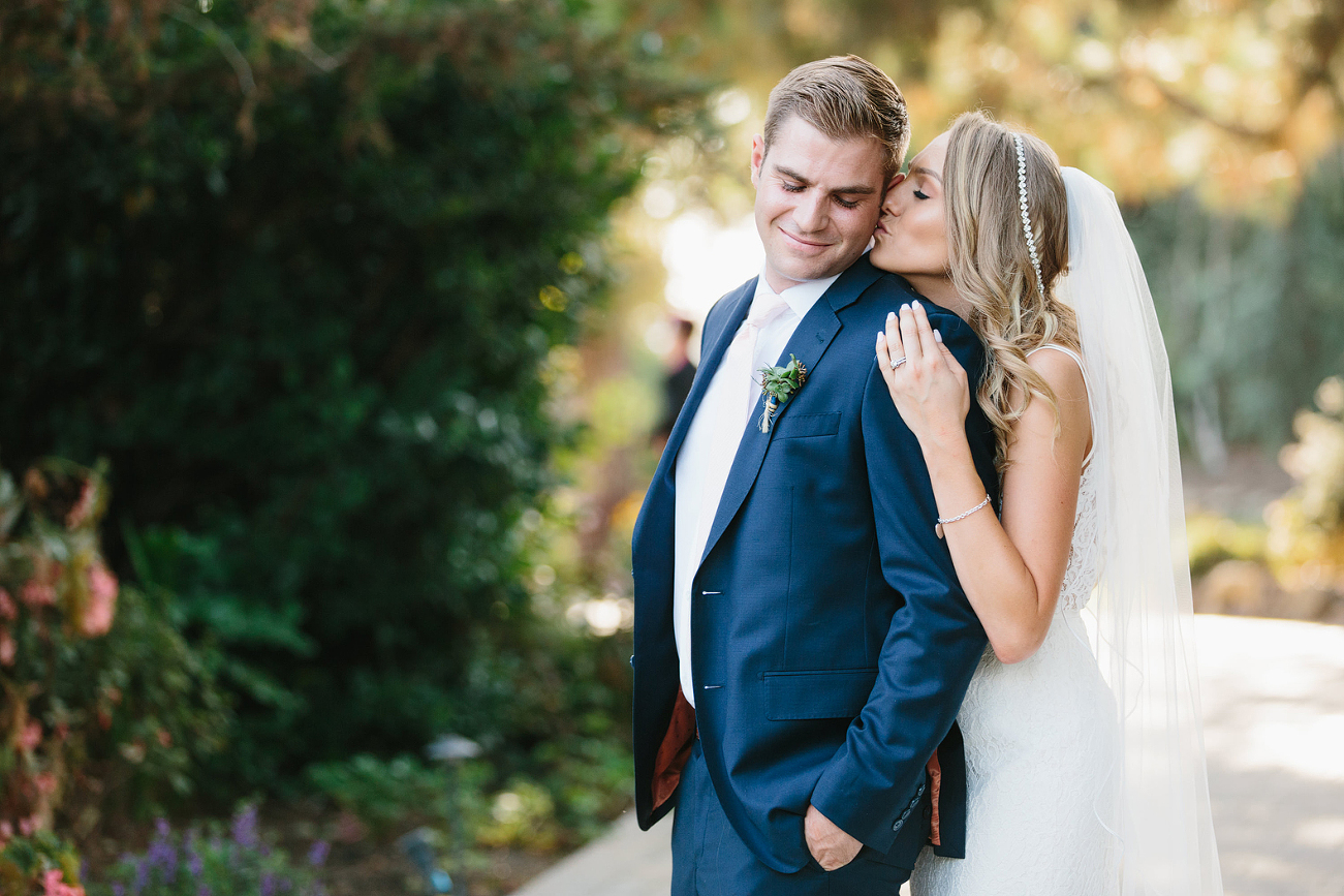 Bride kissing groom on the cheek photo