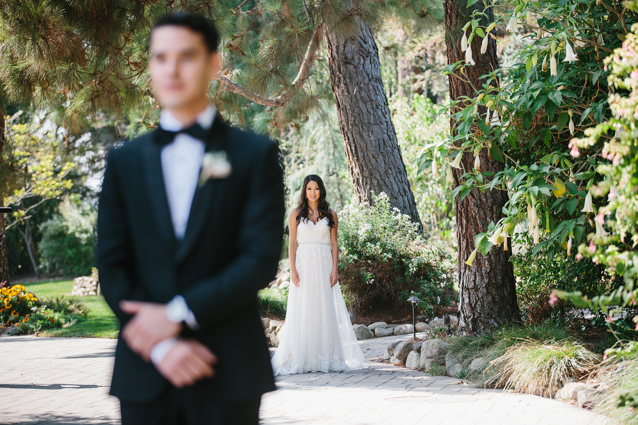 Bride behind groom getting ready to walk up to him