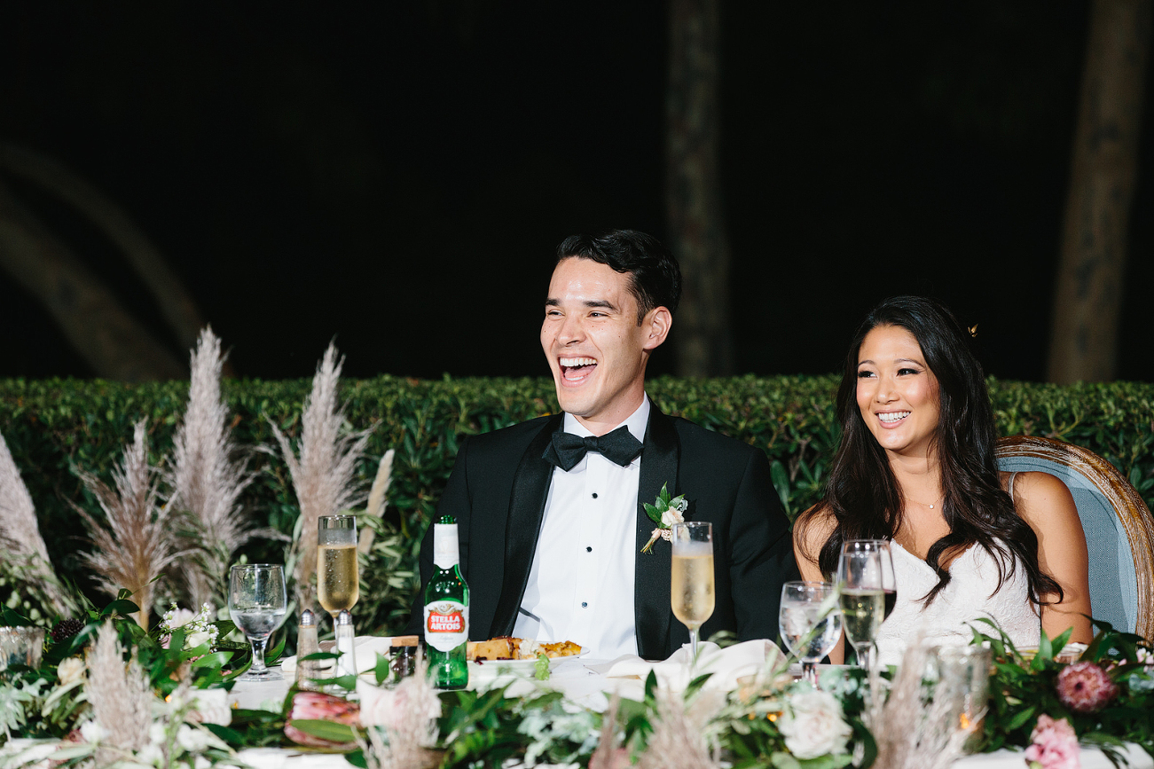 laughing at toasts at wedding reception