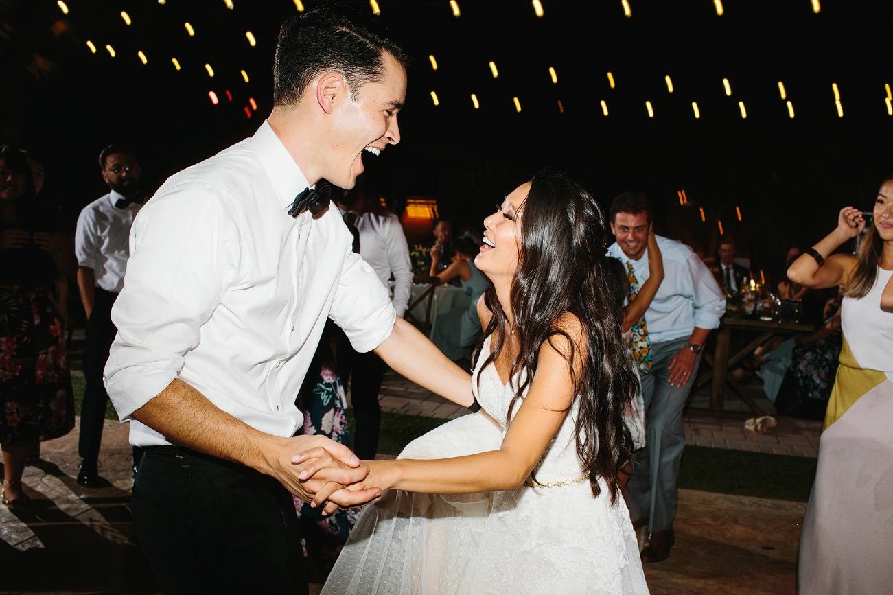 Bride and groom dancing and laughing at their wedding reception