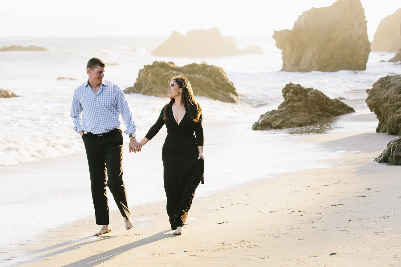 romantic photo of engagement walking on the beach