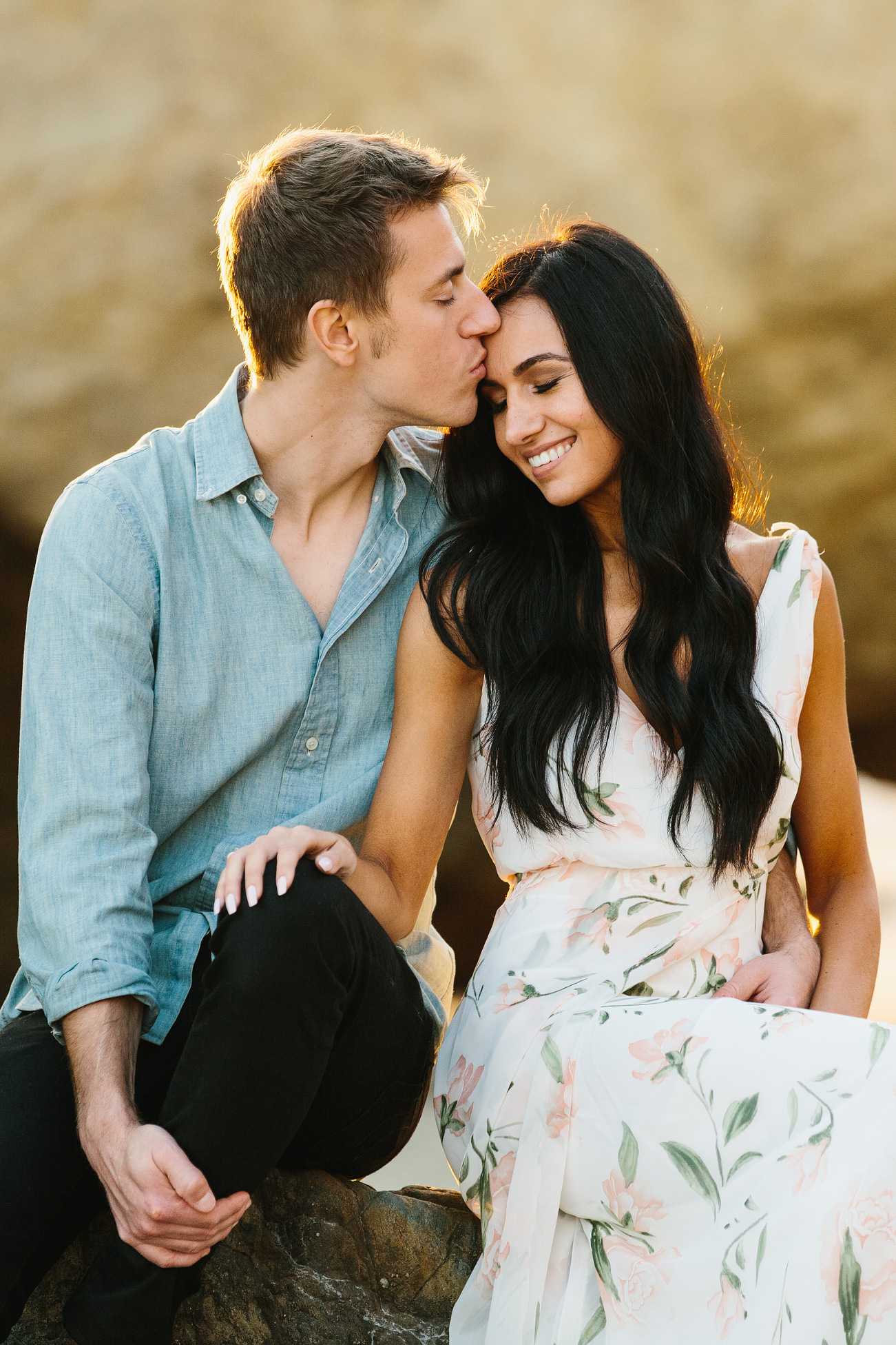 Fiance smiling as her grooms kisses her forehead at their engagement photo session