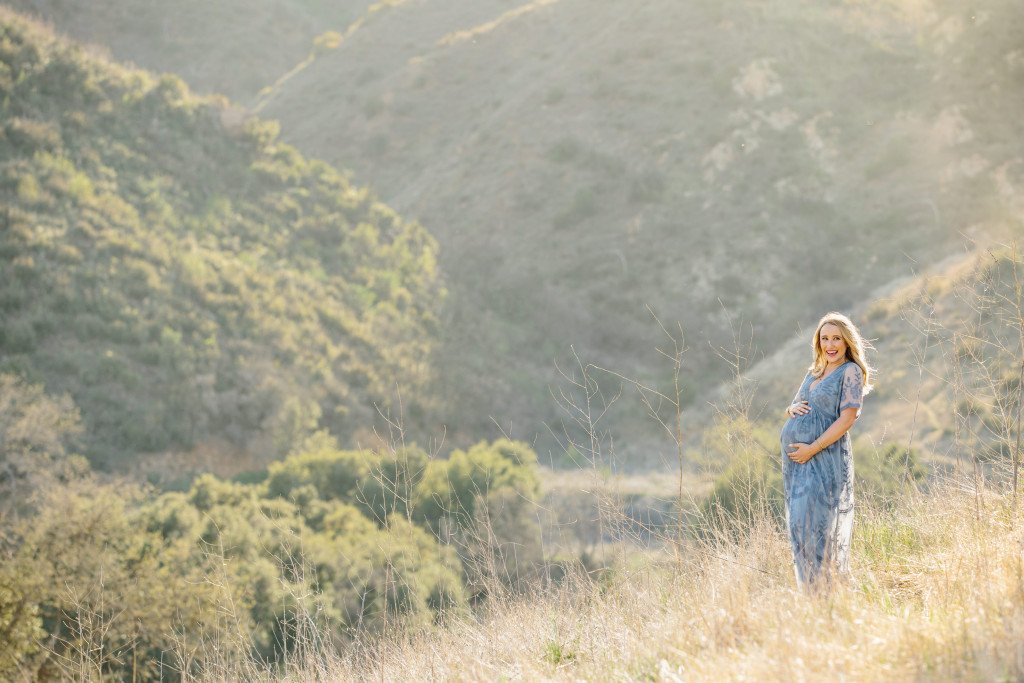 Mom to be at her maternity session in southern california on a hill in glowing light
